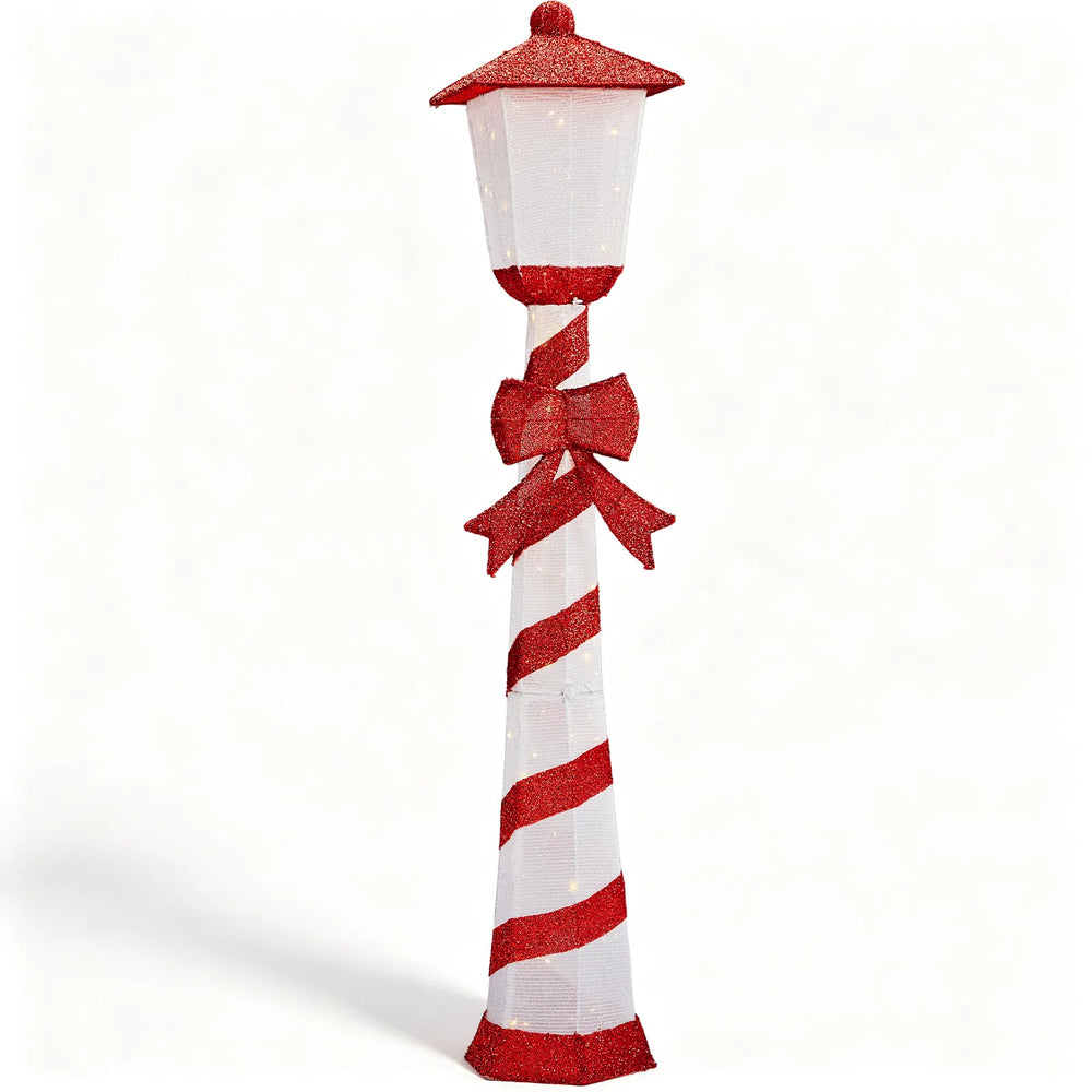 Lighted candy cane striped Christmas lamp post on a porch