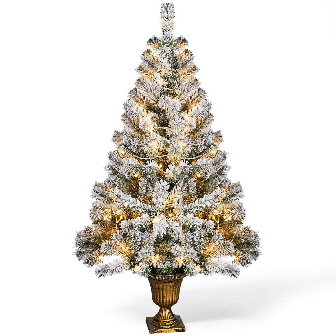 Small flocked Christmas tree in pot lit