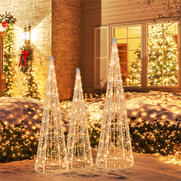 Three lighted cone Christmas trees outdoors