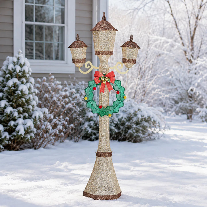 Gold Christmas lamp post with wreath glowing