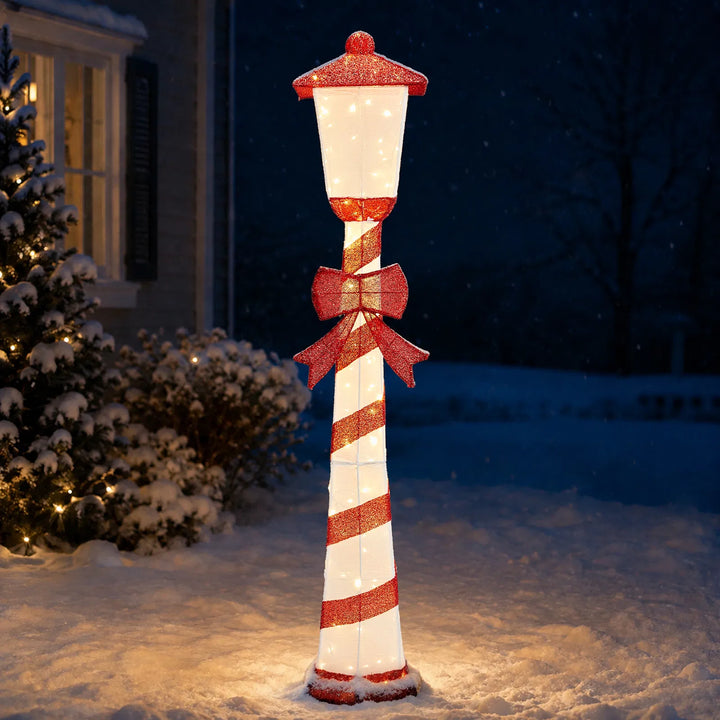 Lighted candy cane striped Christmas lamp post on a porch