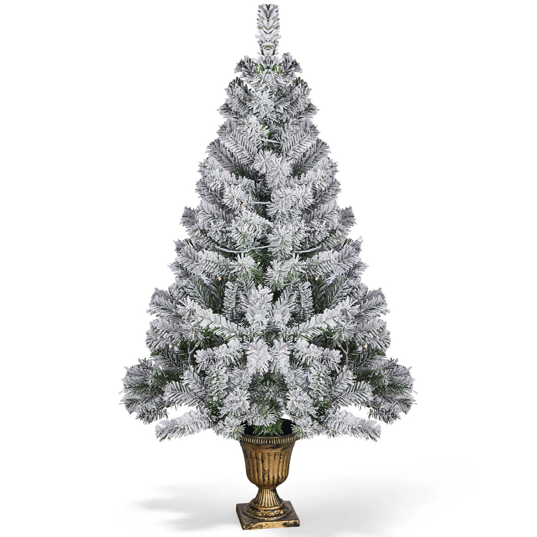 Small flocked Christmas tree in pot lit