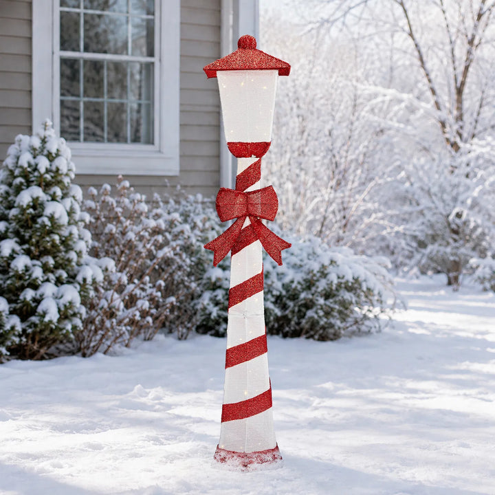 Lighted candy cane striped Christmas lamp post on a porch
